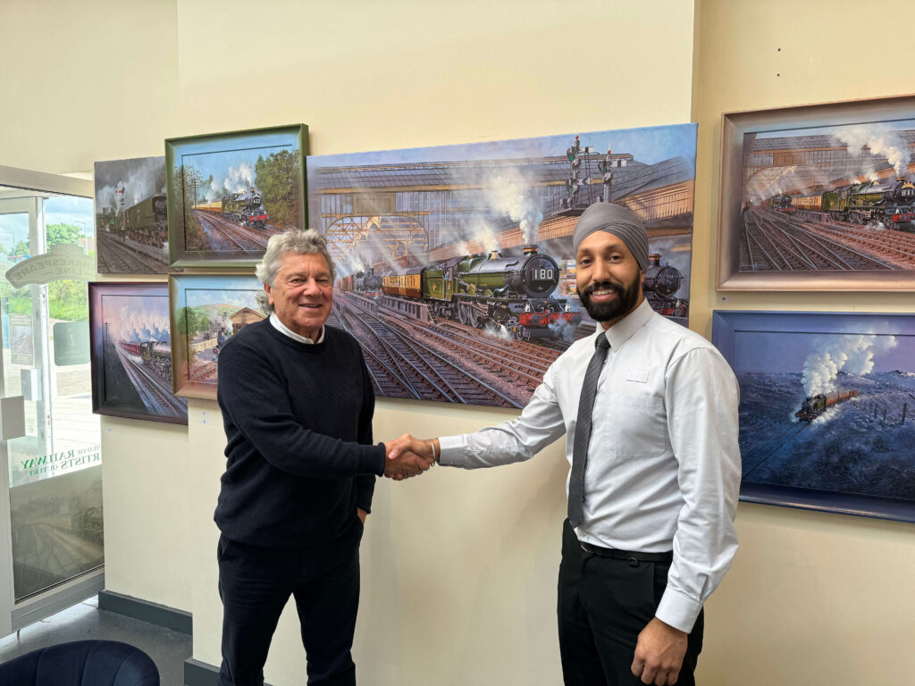 John Austin, FGRA shows some of his paintings to Gurutekh Singh of West Midlands Trains who operate Stratford upon Avon station booking office.